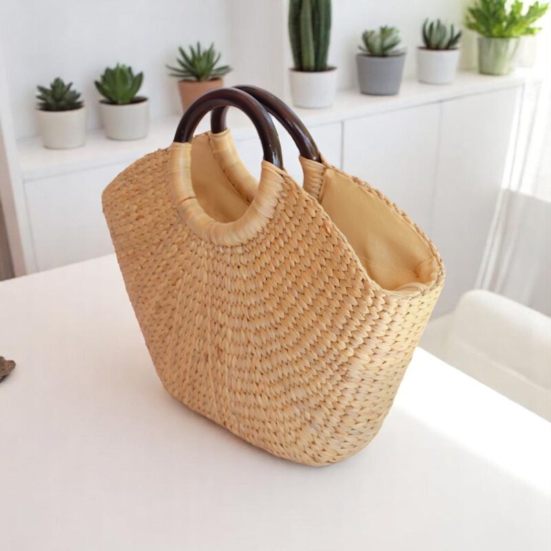 Natural straw tote bag with circular wooden handles and soft lining