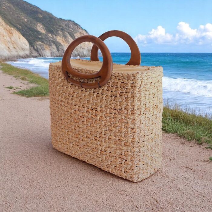 Structured straw bag with oval wooden handles, boxy shape, and natural water hyacinth weave