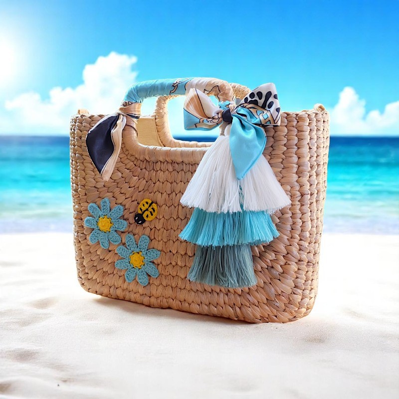Namwan Straw Coastal Tassel Beach Bag – square handmade beach tote with tassels, blue ribbon handles, and floral embroidery
